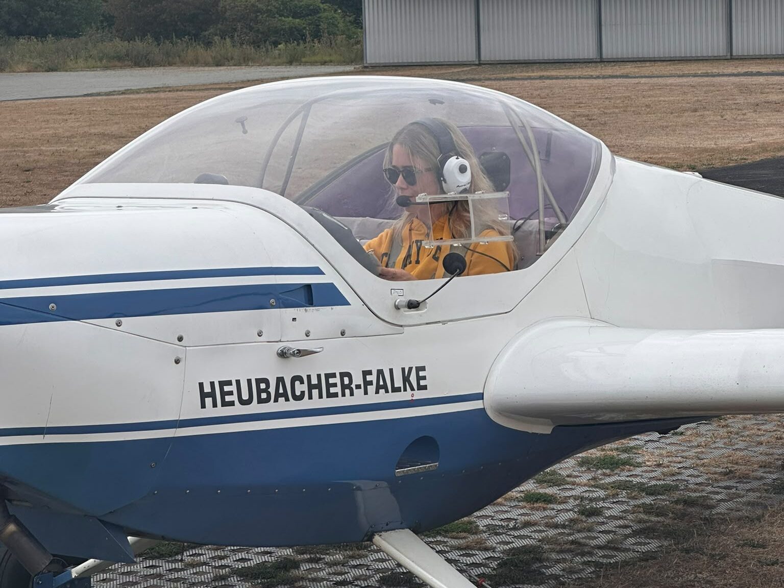 Emilie Meertz mit Headset im Cockpit des Motorseglers SF 25 C „Heubacher Falke“, startbereit am Flugplatz Grefrath-Niershorst
