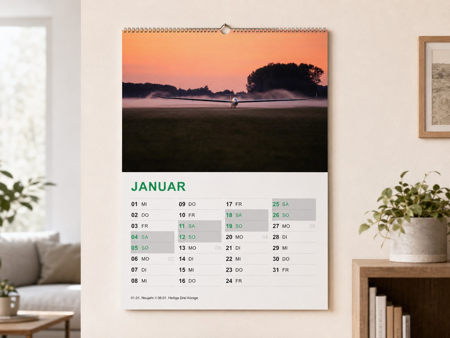 Der Vereinskalender 2027 hängt im Wohnzimmer: oben das Foto eines Segelflugzeugs im Morgennebel bei Sonnenaufgang, darunter das Kalendarium für Januar